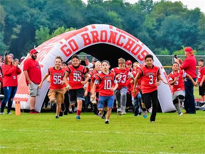 Football Players Running Out of Tunnel